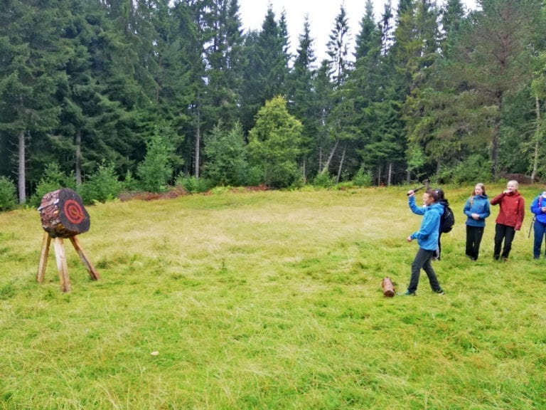 Ungdommar som kastar med øks i skogen