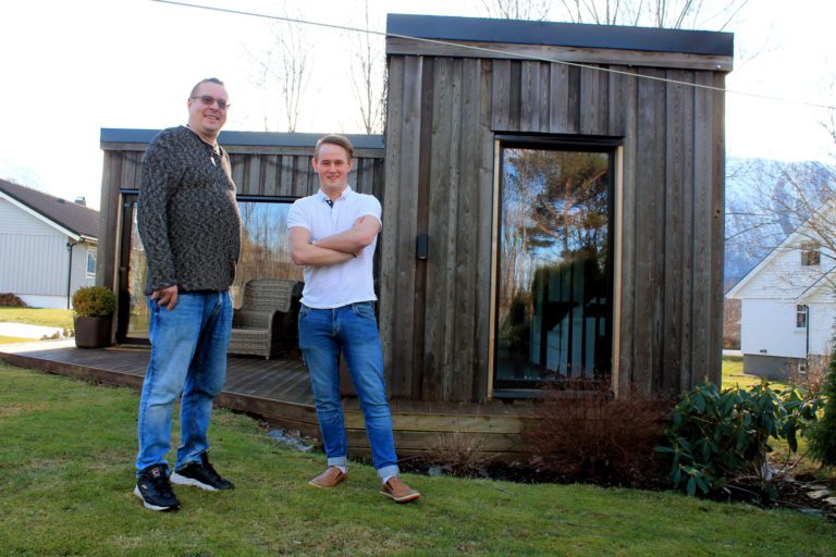 Meeme Tartoo og sonen Maurice framfor minihuset dei sjølv har i hagen heime i Tomrefjord. Denne er bygd av to modular.